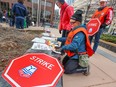 Government workers prepare picket signs outside the federal government Harry Hays Building in downtown Calgary after 155,000 Public Service Alliance of Canada workers went on strike on Wednesday, April 19, 2023.