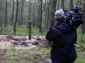 A member of the media holds a camera at the site where the remains of an unidentified military object were found in a northern Polish forest April 27, 2023.