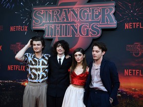 Joe Keery, Finn Wolfhard, Natalia Dyer and Charlie Heaton pose during a photocall for the premiere of season 3 of the Netflix series Stranger Things on July 4, 2019, at the Grand Rex movie theatre in Paris.