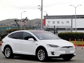 A Tesla vehicle drives past Tesla's primary vehicle factory in Fremont, Calif., May 11, 2020.