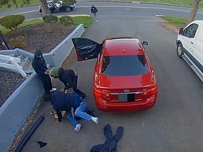 Screenshot of doorbell camera footage of homeowner fighting off group of attempted car thieves