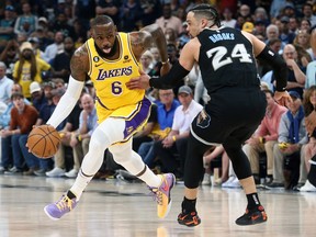 Los Angeles Lakers forward LeBron James dribbles as Memphis Grizzlies forward Dillon Brooks defends during the first half of game two of the 2023 NBA playoffs at FedExForum.