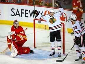 The Chicago Blackhawks celebrate the eventual game-winning goal by forward Austin Wagner against Calgary Flames goaltender Jacob Markstrom at the Scotiabank Saddledome in Calgary on Tuesday, April 4, 2023.