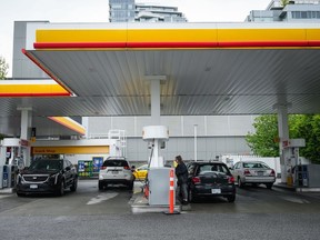 People fuel up vehicles in Vancouver, May 14, 2022. Statistics Canada says retail sales fell 0.2 per cent to $66.3 billion in February as a drop in sales at gasoline stations and fuel vendors and general merchandise stores led the way lower.