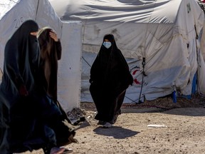 Women walk in Roj detention camp in northeast Syria Wednesday, Feb. 9, 2022.
