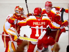 Calgary Wranglers forward Matthew Phillips celebrates with teammates after scoring in overtime against the Abbotsford Canucks during Game 2 of their Pacific Division semifinal at the Scotiabank Saddledome in Calgary on Friday, April 28, 2023. The Wranglers won 4-3.