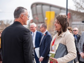 John Bean, president and CEO of Calgary Sports and Entertainment Corporation, left, chats with Premier Danielle Smith before a press conference for an announcement about a future event centre in Calgary on Tuesday, April 25.