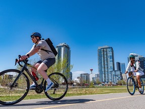People enjoy the warm and sunny weather along the Bow River pathway in East Village on May 5.