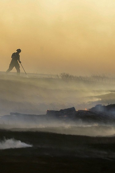 Fire has long been both friend and foe to humankind, with blazes leaving their mark on the history of prairie provinces. Pictured is a firefighter who was part of a team that controlled a wildfire outside of Regina in April 2016.