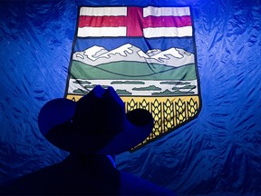 A man in a cowboy hat stands in front of a huge Alberta flag at the UCP watch party on the election night at Big Four Building in Calgary on Monday, May 29, 2023.