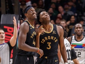 Pascal Siakam #43 and O.G. Anunoby #3 of the Toronto Raptors watch a replay of Anuoby's dunk on the big screen during the first half of their NBA game against the Minnesota Timberwolves at Scotiabank Arena on March 18, 2023 in Toronto.