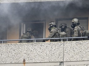 Special police forces enter amid smoke an appartment of a high-rise building, on May 11, 2023 in Ratingen, western Germany, after an explosion occured in which several people were injured including police officers .