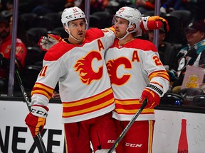 Elias Lindholm (28) celebrates a goal with Mikael Backlund.