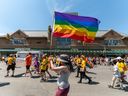 Le chef d'un groupe LGBTQ du centre de l'Alberta dit qu'il n'était pas surpris qu'une candidate qui comparait les élèves transgenres dans les écoles aux excréments dans la nourriture ait remporté son siège lors des élections provinciales de lundi, qui ont vu le Parti conservateur uni remporter un gouvernement majoritaire.  Un participant agite un drapeau arc-en-ciel alors que la foule défile lors du défilé de la fierté à Saskatoon, en Saskatchewan, le samedi 18 juin 2022.