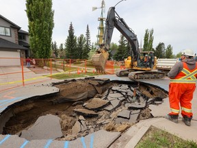 City of Calgary workers begin the repair of a large sinkhole on Wednesday, May 24, 2023 that appeared in Cranston Drive late Tuesday afternoon.