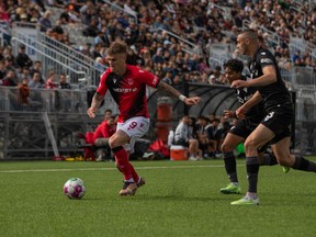 Cavalry FC’s Myer Bevan controls the ball as Vancouver FC players give chase at Willoughby Community Park Stadium in Langley, B.C., on Sunday, May 7, 2023.