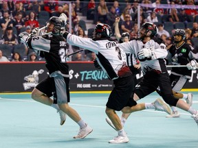 Calgary Roughnecks defender Shane Simpson is chased by Colorado Mammoth defender Tim Edwards (3) and forward Connor Robinson during Game 2 of their West Conference final on WestJet Field at Scotiabank Saddledome on Saturday, May 13, 2023.