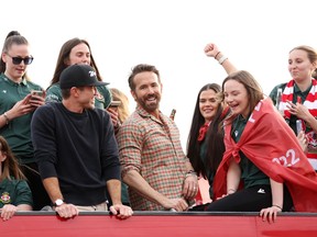 Ryan Reynolds, co-owner of Wrexham, and Rob McElhenney, co-owner of Wrexham, celebrate with players of Wrexham Men and Women during a Wrexham FC Bus Parade following their respective Title Winning Seasons in the Vanarama National League and Genero Adran North in Wrexham, Wales.