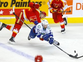 Calgary Wranglers forward Cole Schwindt battles Abbotsford Canucks forward Justin Dowling during Game 2 of their Pacific Division semifinal at the Scotiabank Saddledome in Calgary on April 28, 2023.