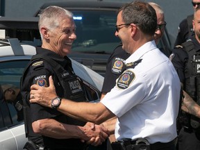 Longueuil police chief Patrick Bélanger, right, congratulates police Sgt. Lionel Bourdon for his 58 years of service, at a brief outdoor ceremony at Longueuil police headquarters marking his last day of service on Thursday June 1, 2023.