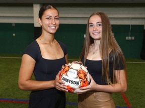Mya Jones (L) and Izzy Monck pose with a ball.