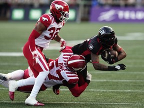 Justin Hardy is tackled by Calgary's Micah Awe.
