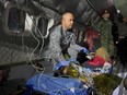 A Colombian soldier checks on one of four Indigenous children on Friday, June 9, 2023, who were found alive after being lost for 40 days in the Amazon rainforest following a plane crash during their transfer to Bogota.