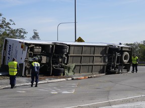 Police inspect a bus on its side near the town of Greta, Australia, following a crash north of Sydney on Monday, June 12, 2023. The bus, which was carrying wedding guests, rolled over on a foggy night in Australia's wine country, killing and injuring multiple people, police said.