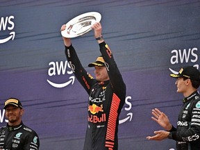Red Bull's Dutch driver Max Verstappen (C) celebrates his first place flaked by Mercedes' British driver Lewis Hamilton (L) and Mercedes' British driver George Russell on the podium of the Spanish Formula One Grand Prix race at the Circuit de Catalunya on June 4, 2023 in Montmelo, on the outskirts of Barcelona.
