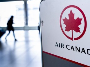 A passenger walks past the Air Canada check-in counter at Montreal-Trudeau International Airport in Montreal, on Wednesday, April 8, 2020.