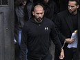 Andrew Tate, centre, and his brother Tristan, leave after appearing at the Court of Appeal, in Bucharest, Romania, Tuesday, Jan.10, 2023.