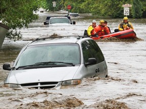 Rescuers evacuate trapped residents through flood waters in High River on Thursday June 20, 2013.