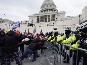 Rioters supporting President Donald Trump try to break through a police barrier at the Capitol in Washington, on Jan. 6, 2021.