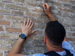 An unidentified tourist carves 'Ivan + Hayley 23' into the Colosseum walls in Rome.