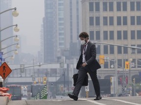 A man walks to work wearing a mask near Parliament Hill, Wednesday, June 7, 2023 in Ottawa. a mask near Parliament Hill, Wednesday, June 7, 2023 in Ottawa. The battle against hundreds of wildfires continued Thursday, as almost every jurisdiction in Canada was under either heat or air quality warnings from the federal government.
