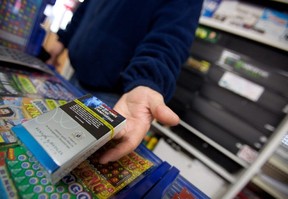 A corner store owner in St. Thomas, Ont, holds a package of cigarettes.