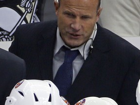 FILE - New York Islanders assistant coach Greg Cronin is shown during the third period of an NHL hockey game against the Pittsburgh Penguins, Saturday, Oct. 18, 2014. The Anaheim Ducks have hired veteran NHL assistant and AHL head coach Greg Cronin to be their new head coach. Ducks general manager Pat Verbeek announced the decision Monday to hire the 60-year-old Cronin, who will be a first-time NHL head coach.