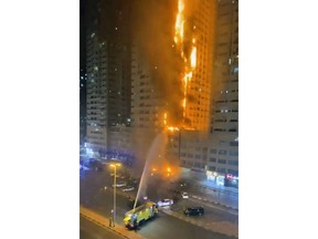 In this image made from the Ajman Police Twitter, fire fighters try to extinguish a residential tower which caught fire early morning on Tuesday, June 27, 2023, in Ajman, United Arab Emirates.