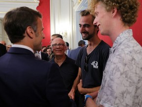 French President Emmanuel Macron (left) shakes hands Henri (second from right), the 24-year-old known as the "backpack hero," who suffered minor stab wounds as he tried to stop the fleeing suspect, during a meeting with rescue forces at the Haute-Savoie prefecture, a day after a mass stabbing in a park, in Annecy, in the French Alps, France, on June 9, 2023.