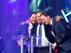 From left, Brayden Logel, executive vice-president, Tim Logel, president and CEO and Kevin Logel, construction manager, of Logel Homes celebrate on stage after receiving the platinum level award at Deloitte's 2023 Canada's Best Managed Companies awards.