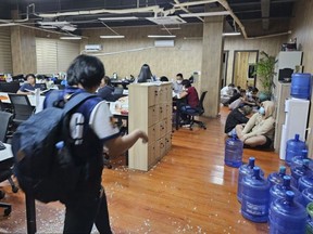 In this handout photo provided by the Philippine National Police Anti-Cybercrime Group, a police officer walks inside one of the offices they raided in Las Pinas, Philippines on Tuesday June 27, 2023.