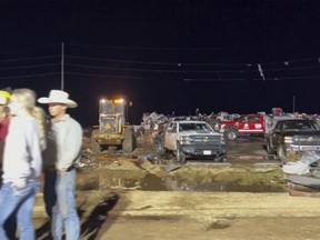 In this image made from video provided by KAMC/KLBK, people stand near debris in Matador, Texas, Wednesday, June 21, 2023.