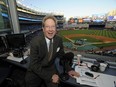 This Sept. 25, 2009 file photo shows New York Yankees broadcaster John Sterling sitting in his booth before a baseball game against the Boston Red Sox at Yankee Stadium in New York.