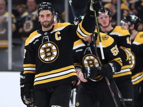 Patrice Bergeron of the Boston Bruins waves to fans before exiting the ice.