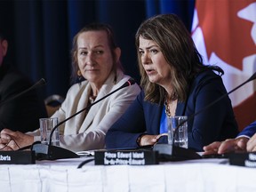 Caroline Cochrane, left, Premier of the Northwest Territories, listens in as Danielle Smith, Premier of Alberta, speaks to media during the closing news conference at the Council of the Federation Canadian premiers meeting at The Fort Garry Hotel in Winnipeg, Wednesday, July 12, 2023.