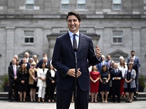 Le premier ministre Justin Trudeau fait un geste vers le cabinet fédéral alors qu'il se tient derrière lui lors d'un point de presse après un remaniement ministériel, à Rideau Hall à Ottawa, le mercredi 26 juillet 2023.