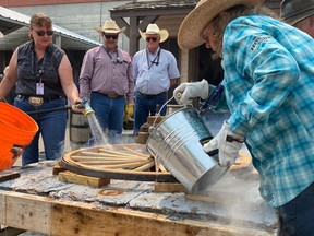 Wheelwright Randy Wolfe and members of the Western Canadian Wheelwrights Association perform a wheel-making demonstration at the Calgary Stampede on Saturday, July 15. Photo by Michael Rodriguez/Postmedia