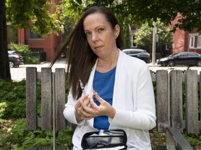 Candice Chaffey holds a syringe from a naloxone kit as she poses for a photo in Toronto, on Thursday, June 29, 2023.