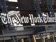 FILE - A sign for The New York Times hangs above the entrance to its building, May 6, 2021, in New York. The New York Times is getting rid of its sports department and will instead rely on sports coverage from its website The Athletic going forward, according to a report on the media company's website. The move impacts more than 35 people in the sports department. The report on Monday, July 10, 2023 said that journalists on the sports desk will move to other roles in The New York Times newsroom and that there were no planned layoffs.