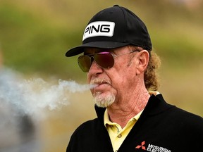 Miguel Angel Jimenez blows cigar smoke during Day Two of The Senior Open.